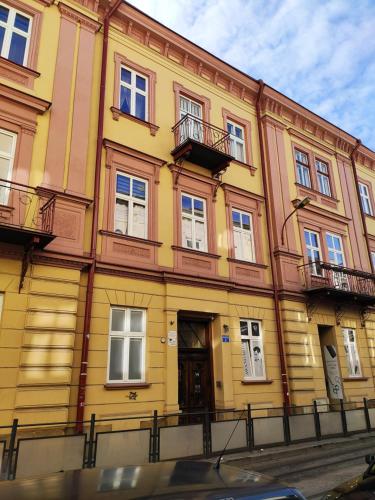 ein gelbes Gebäude auf einer Stadtstraße in der Unterkunft City-Center Apartment in Przemyśl