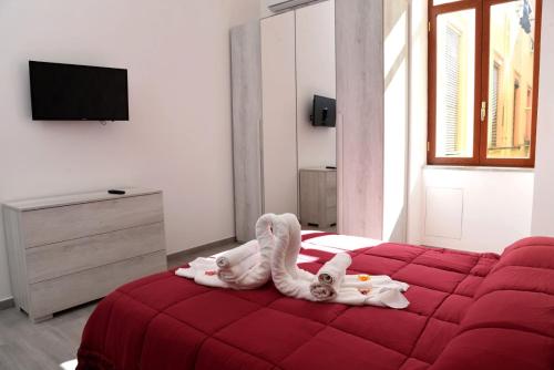 een slaapkamer met een rood bed met twee dieren erop bij Casa Sammarco in Napels