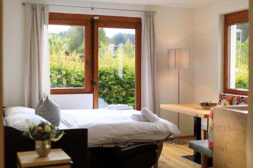 1 dormitorio con cama, escritorio y ventana en Laura´s Smart Apartment, en Innsbruck