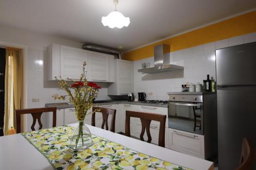 una cocina con una mesa con un jarrón de flores. en Casa Vacanze Al Borgo, en Caprino Veronese
