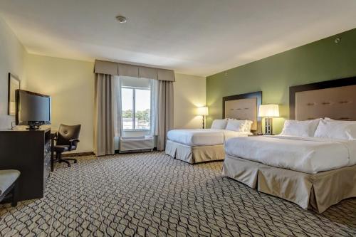 a hotel room with two beds and a television at Holiday Inn Poplar Bluff by IHG in Poplar Bluff