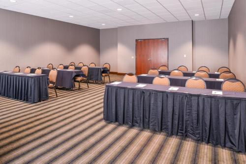 a conference room with tables and chairs and a podium at Holiday Inn Poplar Bluff by IHG in Poplar Bluff