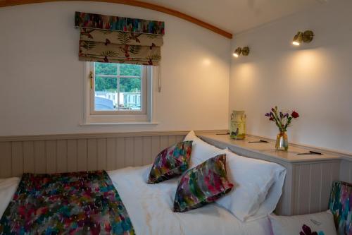 a bedroom with a bed with two pillows and a window at Shepherd Hut Bird Enniskillen, Fermanagh in Enniskillen