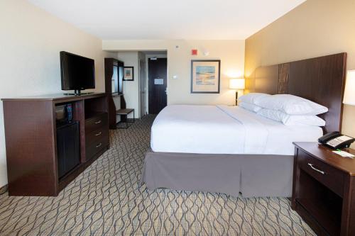 a hotel room with a bed and a flat screen tv at Holiday Inn St. Louis Airport West Earth City by IHG in Earth City