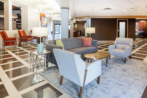 a lobby of a hotel with chairs and couches at Holiday Inn St. Louis Airport West Earth City by IHG in Earth City
