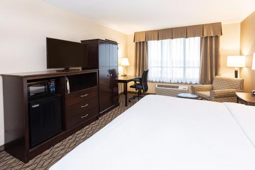 a hotel room with a bed and a flat screen tv at Holiday Inn St. Louis Airport West Earth City by IHG in Earth City