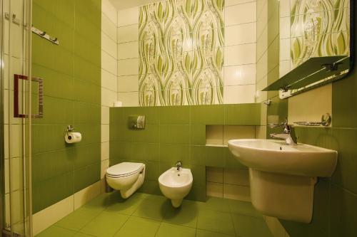 La salle de bains verte est pourvue d'un lavabo et de toilettes. dans l'établissement Apartamenty przy Głównym Deptaku, à Wisła