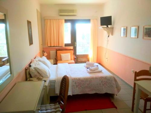 a small bedroom with a bed and a window at Rent Rooms Alexiou in Límni