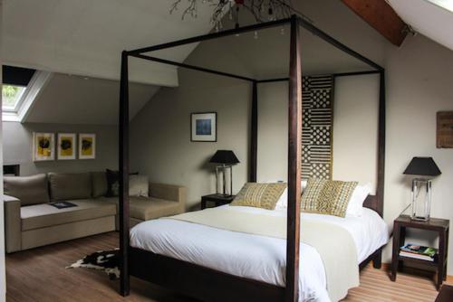 デイルベークにあるCosy Lodgeのベッドルーム(天蓋付きベッド1台、ソファ付)