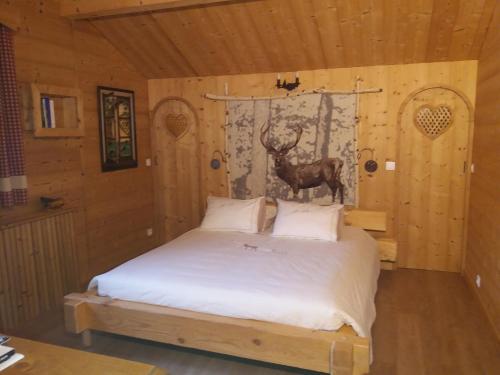 een slaapkamer met een bed met een hert aan de muur bij Chambres d’Hôtes les Hermines in Saint-Nicolas-la-Chapelle