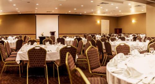 uma sala de conferências com mesas e cadeiras e um pódio em Holiday Inn & Suites Port Moresby, an IHG Hotel em Porto Moresby