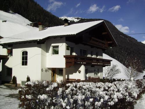 a white house with snow on top of it at Ferienwohnung Alpenheim in Tux