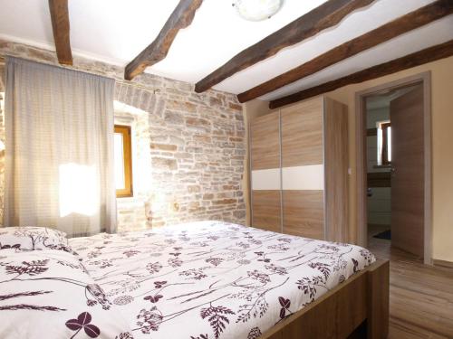 a bedroom with a bed and a brick wall at House Jasici 2014 in Žminj