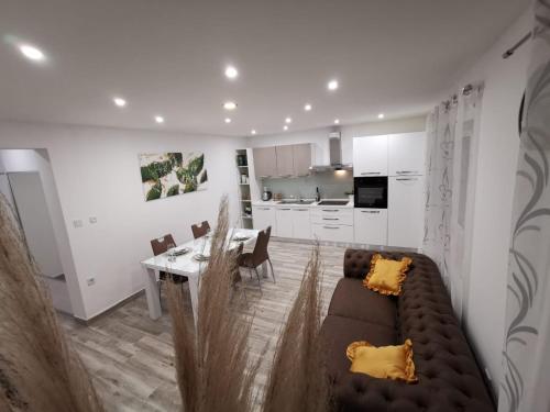 ein Wohnzimmer mit einem Sofa und einem Esszimmer in der Unterkunft Apartmani Pina 1 in Kaštela