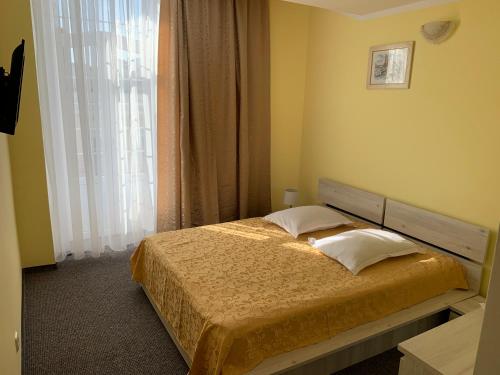 a bedroom with a bed and a large window at Hotel Rares in Botoşani