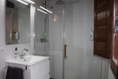 y baño blanco con lavabo y ducha. en Ca' la Paz - Mogarraz, en Mogarraz