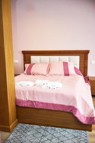 a bedroom with a bed with pink and white sheets at Східний in Brzezhany