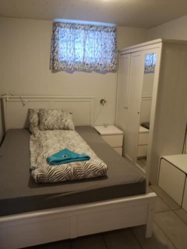a small bedroom with a bed with a blue item on it at Malvik, Hundhamaren, Trondheim in Malvik