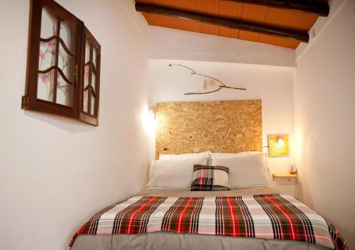 a bedroom with a bed with a plaid pillow on it at monte da boa fé in Estremoz