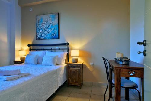 a bedroom with a bed and a desk with a chair at House in Εndless green - Arethousa, Ikaria in Évdhilos