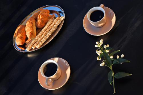 a table with a plate of corn and cups of coffee at House in Εndless green - Arethousa, Ikaria in Évdhilos