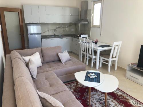 sala de estar con sofá, mesa y cocina en Rooftop Apartments Lungomare en Vlorë