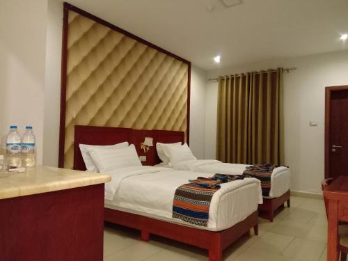 um quarto de hotel com duas camas e uma mesa em seven7days hotel em Aqaba