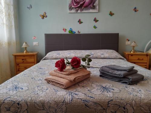 Un dormitorio con una cama con toallas y rosas. en Come a casa - near VENEZIA, en Oriago Di Mira