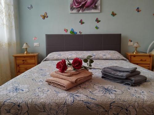 a bedroom with a bed with towels and roses on it at Come a casa - near VENEZIA in Oriago Di Mira