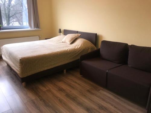 - une chambre avec un lit et un canapé dans l'établissement Centro apartamentai - Vingio apartamentai, à Vilnius