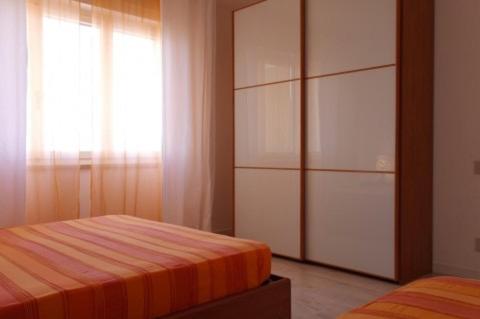 ein Schlafzimmer mit einem Bett, einer Kommode und einem Fenster in der Unterkunft Orange Home in Marina di Castagneto Carducci