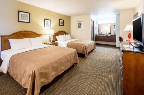 a hotel room with two beds and a flat screen tv at Quality Inn Keystone near Mount Rushmore in Keystone