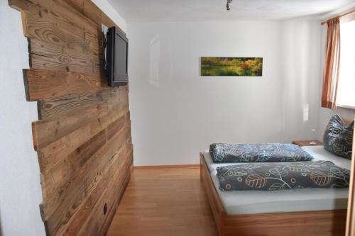 ハウス・イム・エンスタールにあるAppartement Sabrinaの木のアクセントの壁とソファが備わる客室です。
