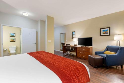 a hotel room with a bed and a chair and a desk at Comfort Inn & Suites Near Ontario Airport in Ontario