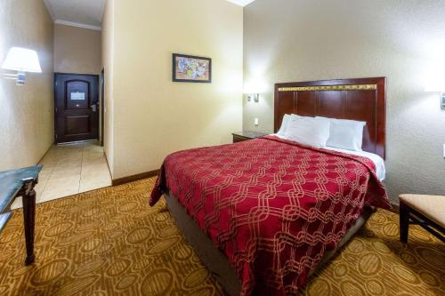 a hotel room with a bed with a red blanket at Econo Lodge Inn & Suites Fallbrook Downtown in Fallbrook