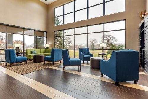 a waiting room with blue chairs and windows at Comfort Suites Elkhart South in Elkhart