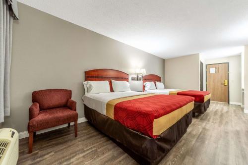a hotel room with two beds and a chair at Econo Lodge Lincoln in Lincoln
