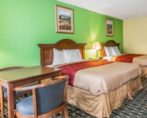 a hotel room with two beds and a table at Econo Lodge Douglas in Douglas