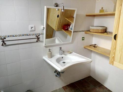 a bathroom with a sink and a mirror at REFÚGIO DO RAPOSO/CASA DENEB (CC) in Montes da Senhora