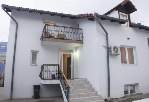 een wit huis met een trap en een balkon bij Adi&Nicol in Sibiu