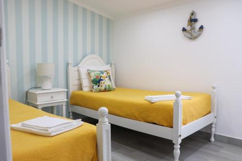 ナザレにあるFlipflops Apartments 3のベッドルーム1室(黄色いシーツを使用したベッド2台付)
