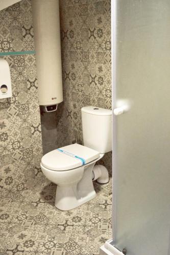 a bathroom with a white toilet in a stall at Східний in Brzezhany