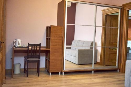 a room with a desk and a chair and a mirror at Східний in Brzezhany