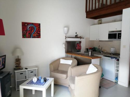 un salon avec deux chaises et une table dans l'établissement Le Soleil et la Mer, à Pornichet