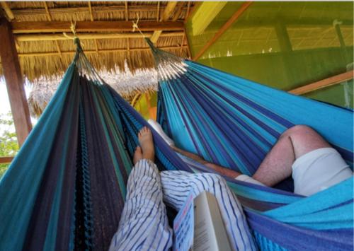 a person sleeping in a hammock in a tent at Grand Amazon Lodge and Tours - All Inclusive in Paraíso