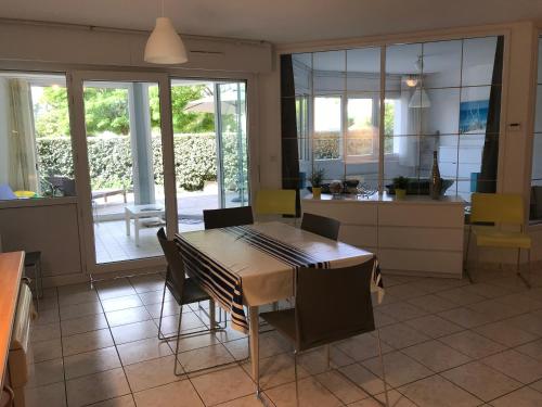 une cuisine et une salle à manger avec une table et des chaises dans l'établissement le Cap Landais, à Capbreton