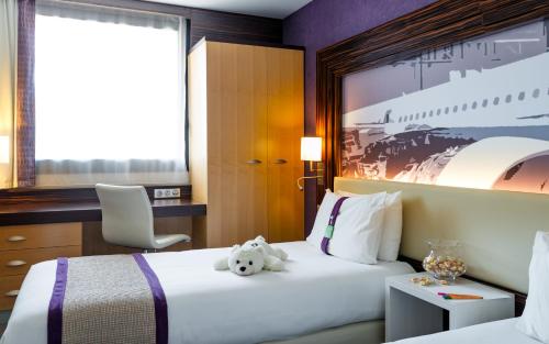 a hotel room with two beds with a teddy bear at Holiday Inn Toulouse Airport by IHG in Blagnac