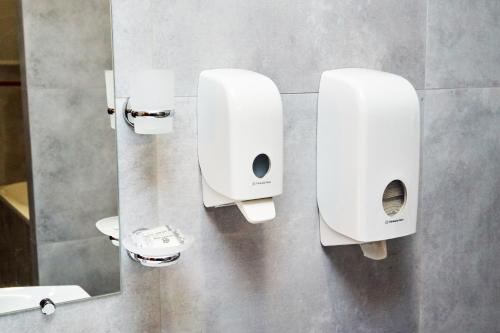 a bathroom with two toilet paper dispensers on the wall at Східний in Brzezhany