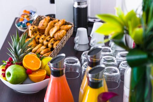 a table with a basket of food and a bowl of fruit at Holiday Inn Toulouse Airport by IHG in Blagnac