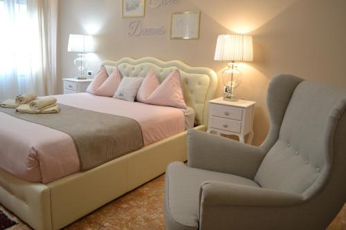 a bedroom with a large bed and a chair at SAN MARCO3 Apartment in Venice